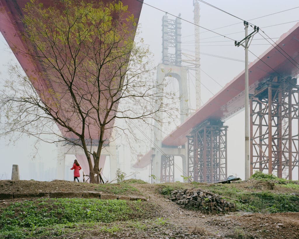 mujer caminando por debajo de una urbanización de autopistas y niebla