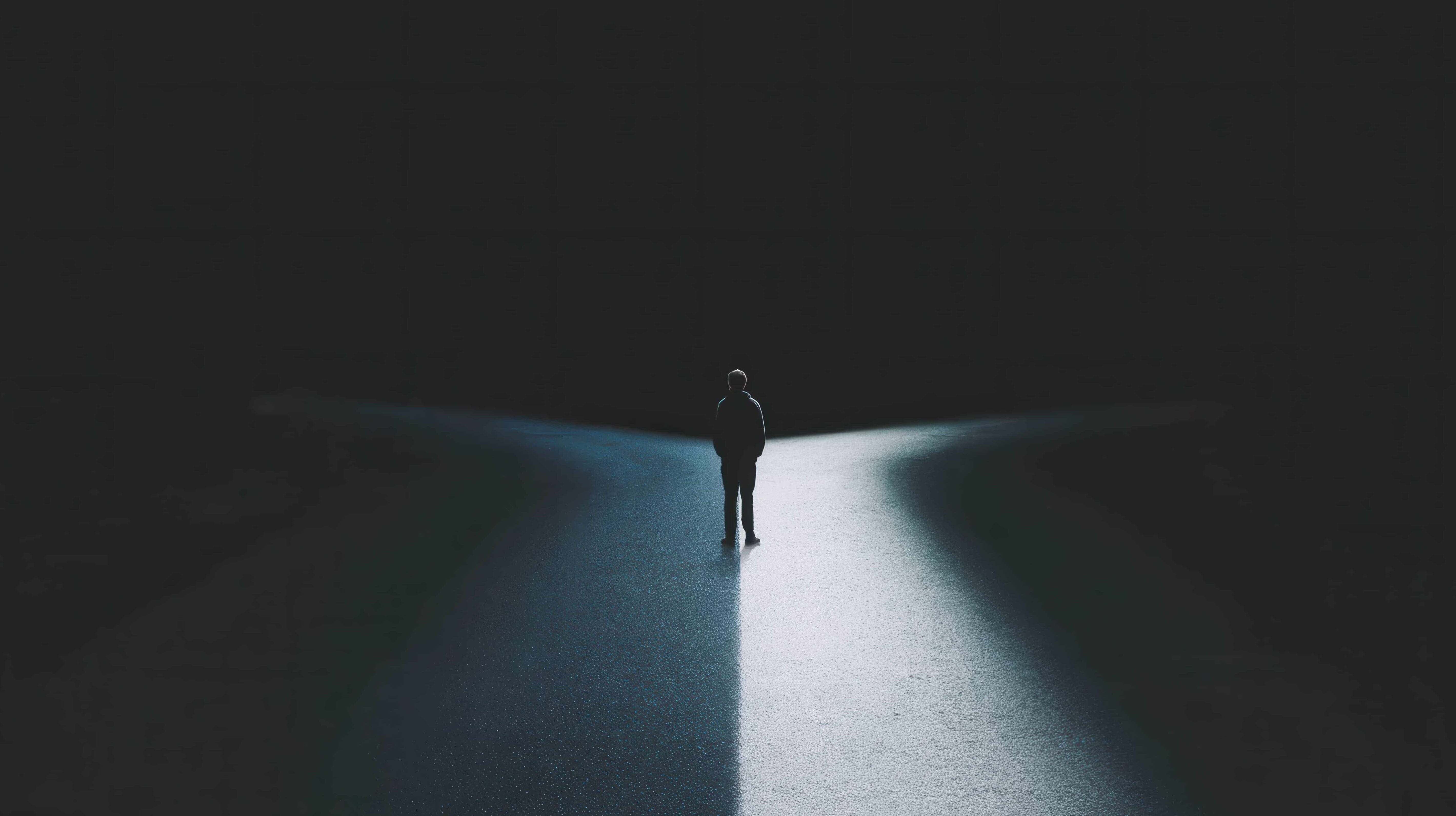 teenager standing on road between dark and light path choices