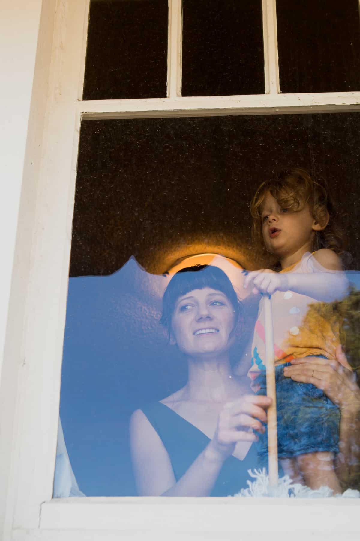 Mamá y niña en la ventana