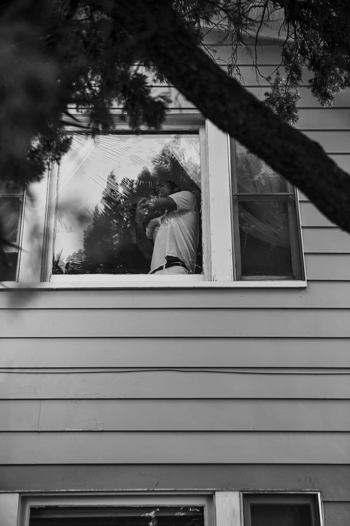 Black and White photo of man behind the window