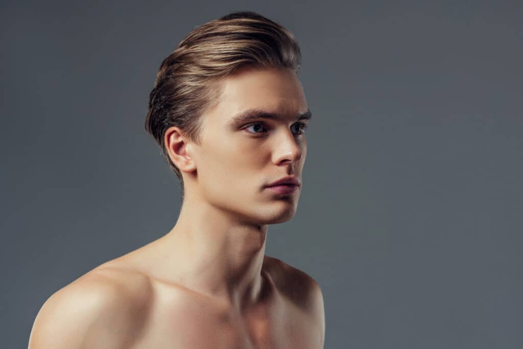 Handsome male glamour model on grey background