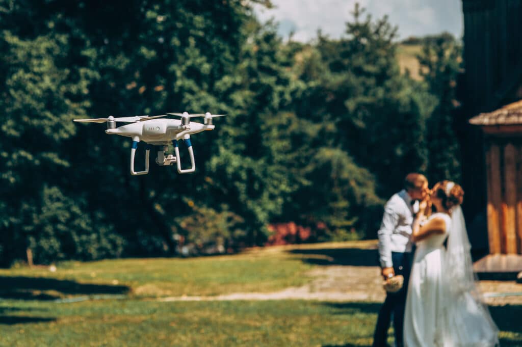 Drohnenpilot macht Fotos von einem Hochzeitspaar in der Natur