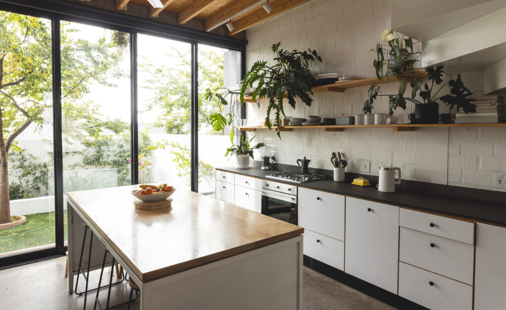 Blick in eine moderne Wohnküche mit Fenstertüren zum kleinen Garten