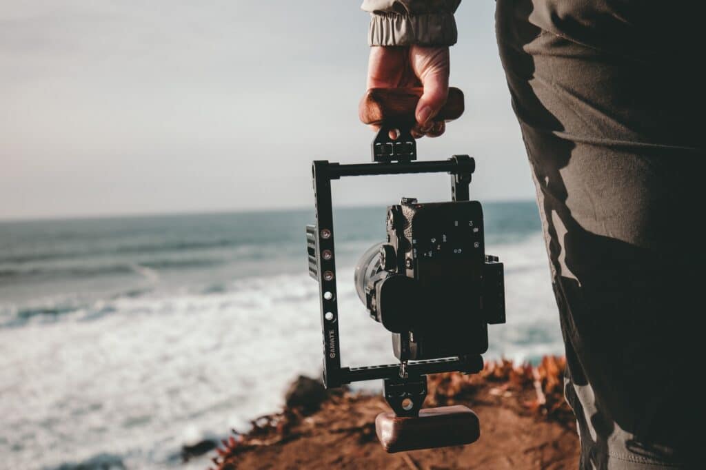 Câmera DSLR no gimbal sendo segurada ao lado da pessoa