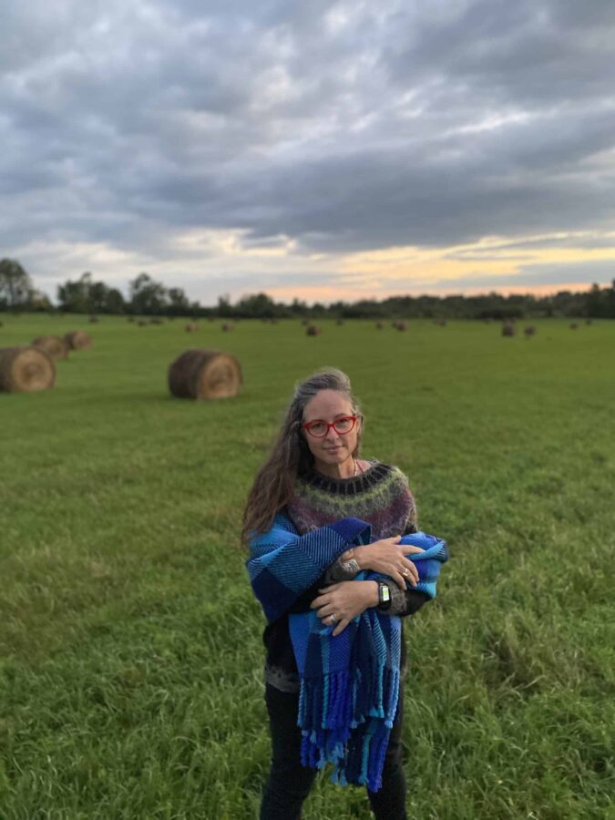 Liz Pead usando um cobertor em um campo de feno em escala e1692896954166