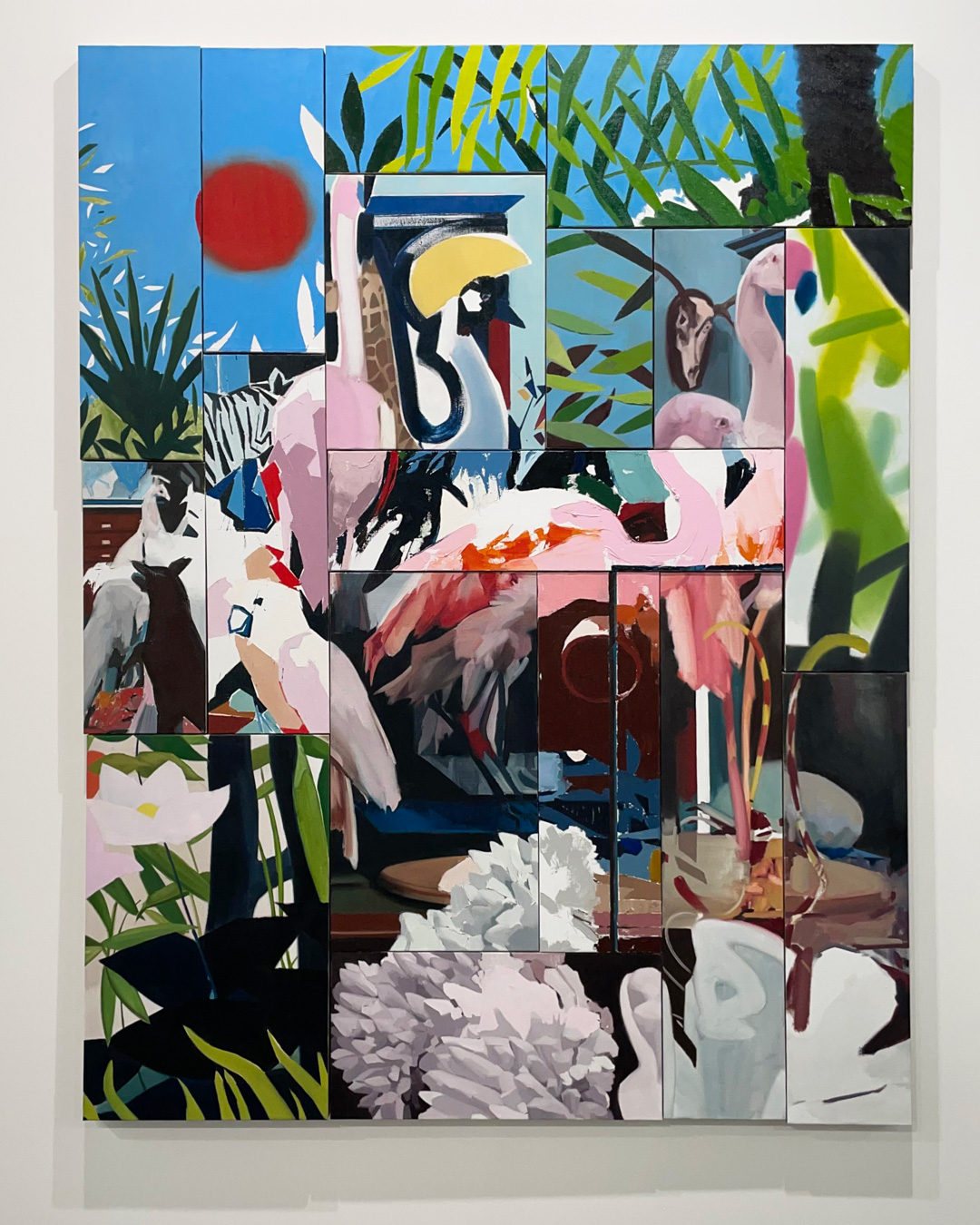 Un gran cuadro rectangular se compone de paneles cuadrados más pequeños, cada uno de los cuales representa un elemento diferente de una vibrante escena tropical con animales, plantas y un sol rojo sobre un cielo azul. La composición fragmentada crea un efecto de collage, mezclando imágenes de flamencos, cebras, cisnes, loros y exuberante follaje. Pintura de Nacho Martín Silva