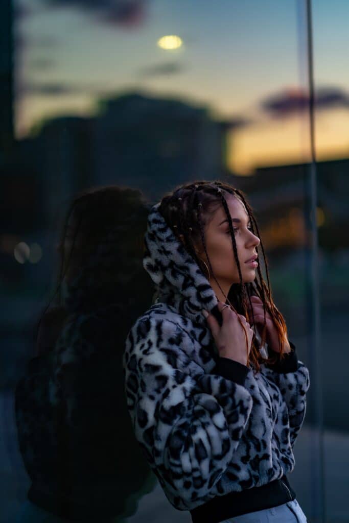 une femme avec des dreadlocks devant une fenêtre