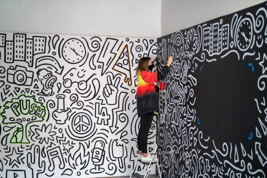 artiste créant une installation ou une peinture murale communautaire à grande échelle en noir et blanc
