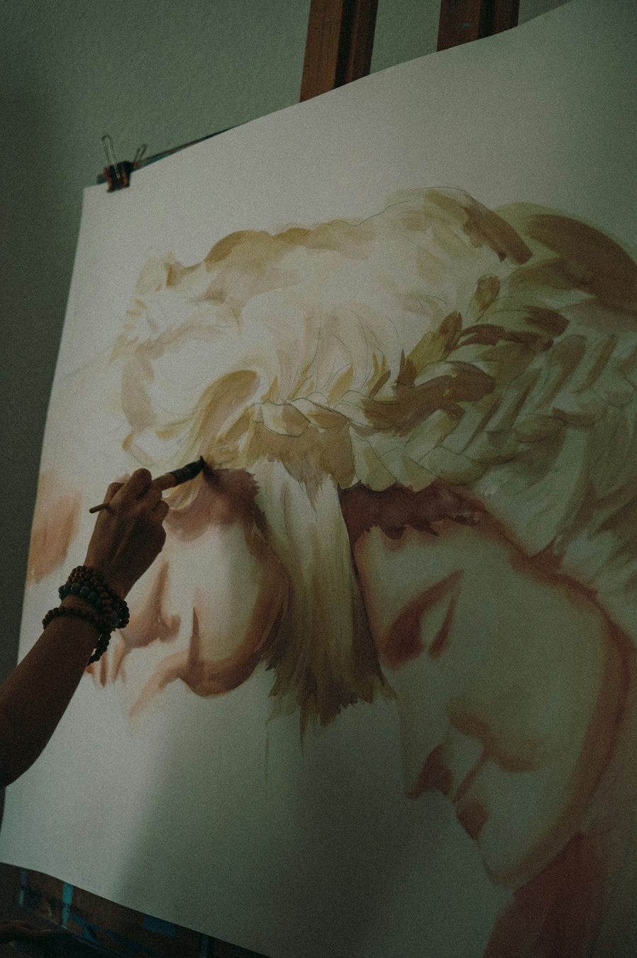 artist painting portraits on an easel