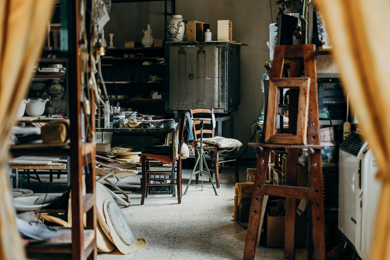 artist studio filled with pottery and painting paraphernalia