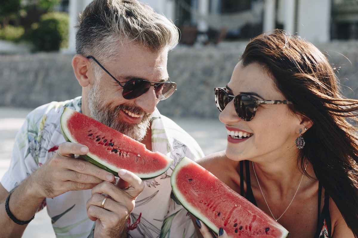couple-eating-watermelon-at-the-beach-WC8QYH3