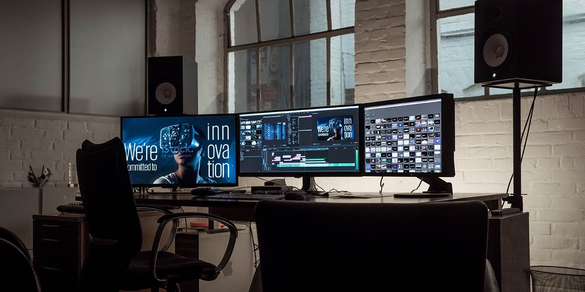 desk-with-3-monitors-video-editing-software