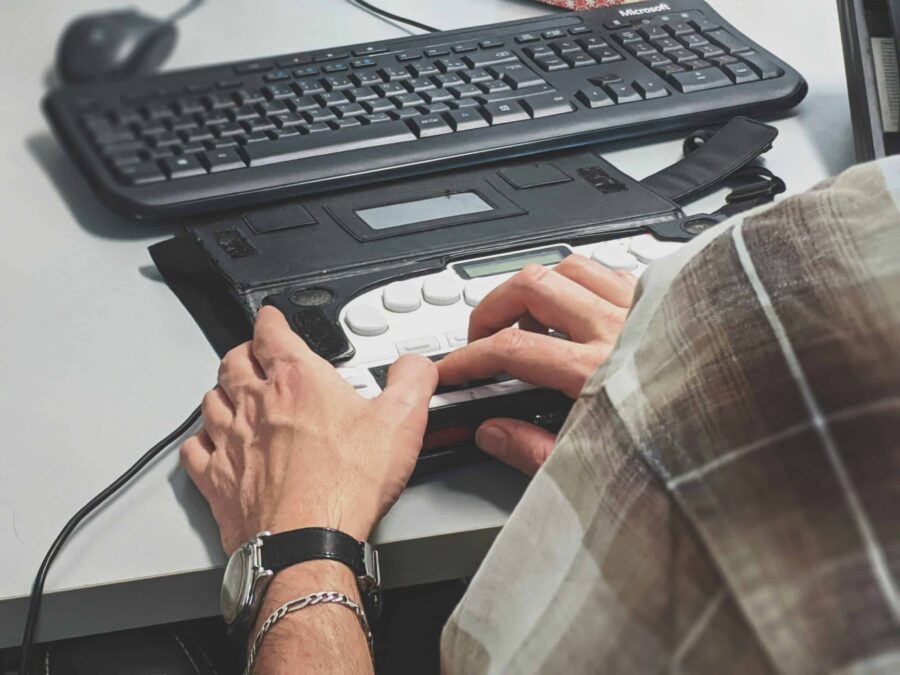 hands resting on buttons on an accessible keyboard scaled e1711983237713