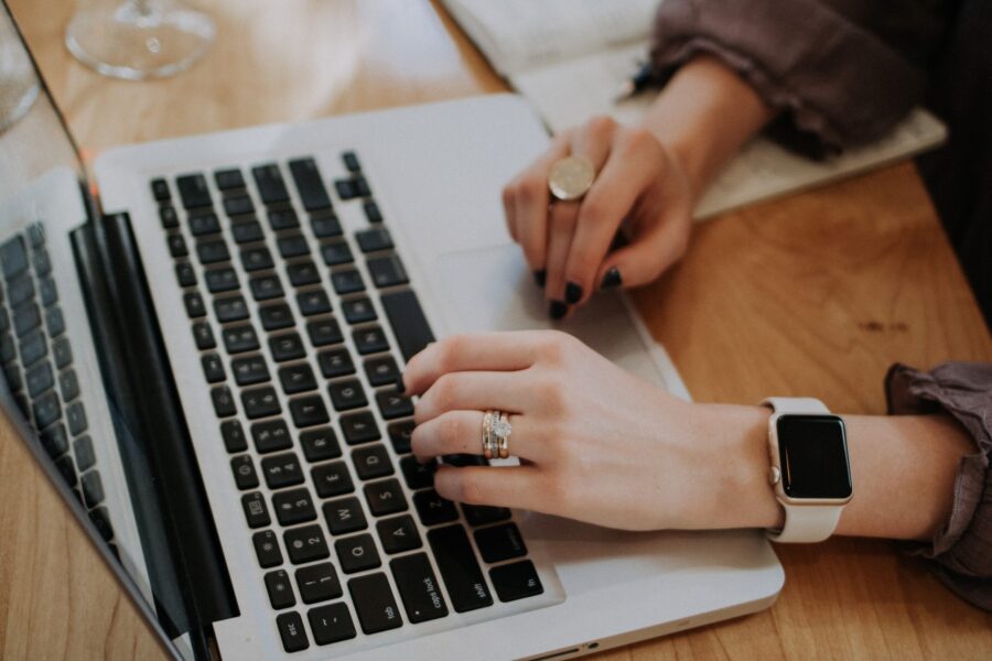 mains reposant sur le clavier et le tapis de souris d'un chromebook sur une table en bois à l'échelle e1701183657302