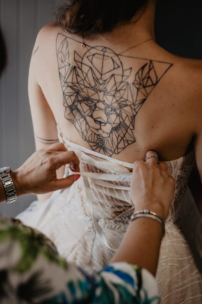 large linear tattoo between woman's shoulder blades