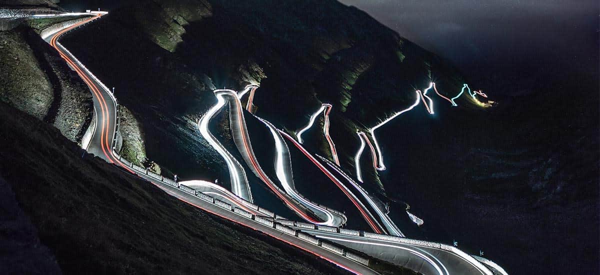 longa exposição de uma estrada de montanha com trilhas para carros