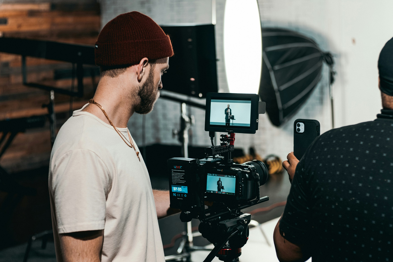 man recording video with a large video camera on a tripod in a studio