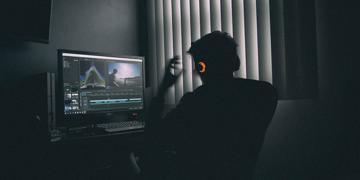 man-sitting-in-the-dark-editing-video