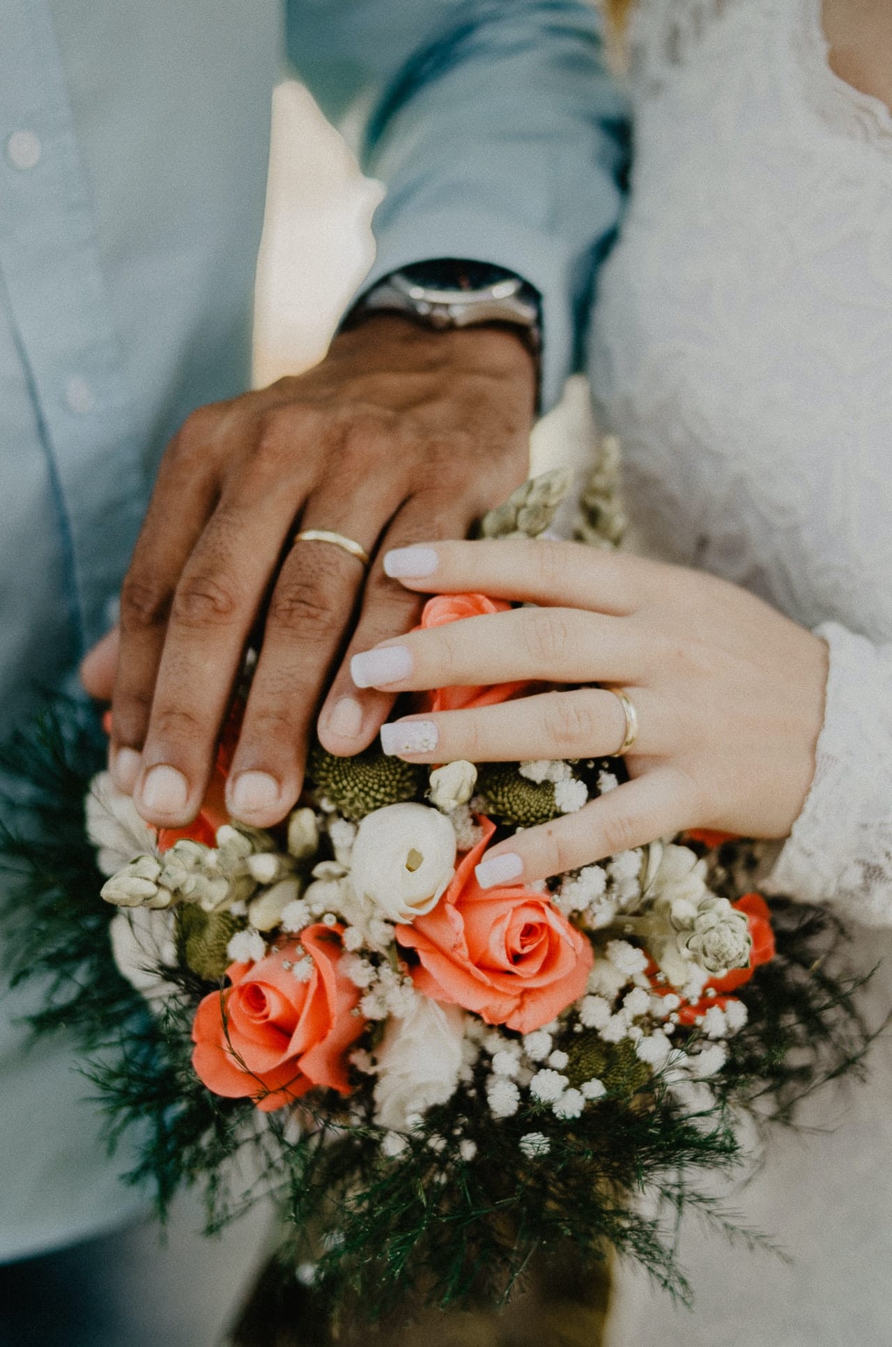man and woman-s hand on bouquet