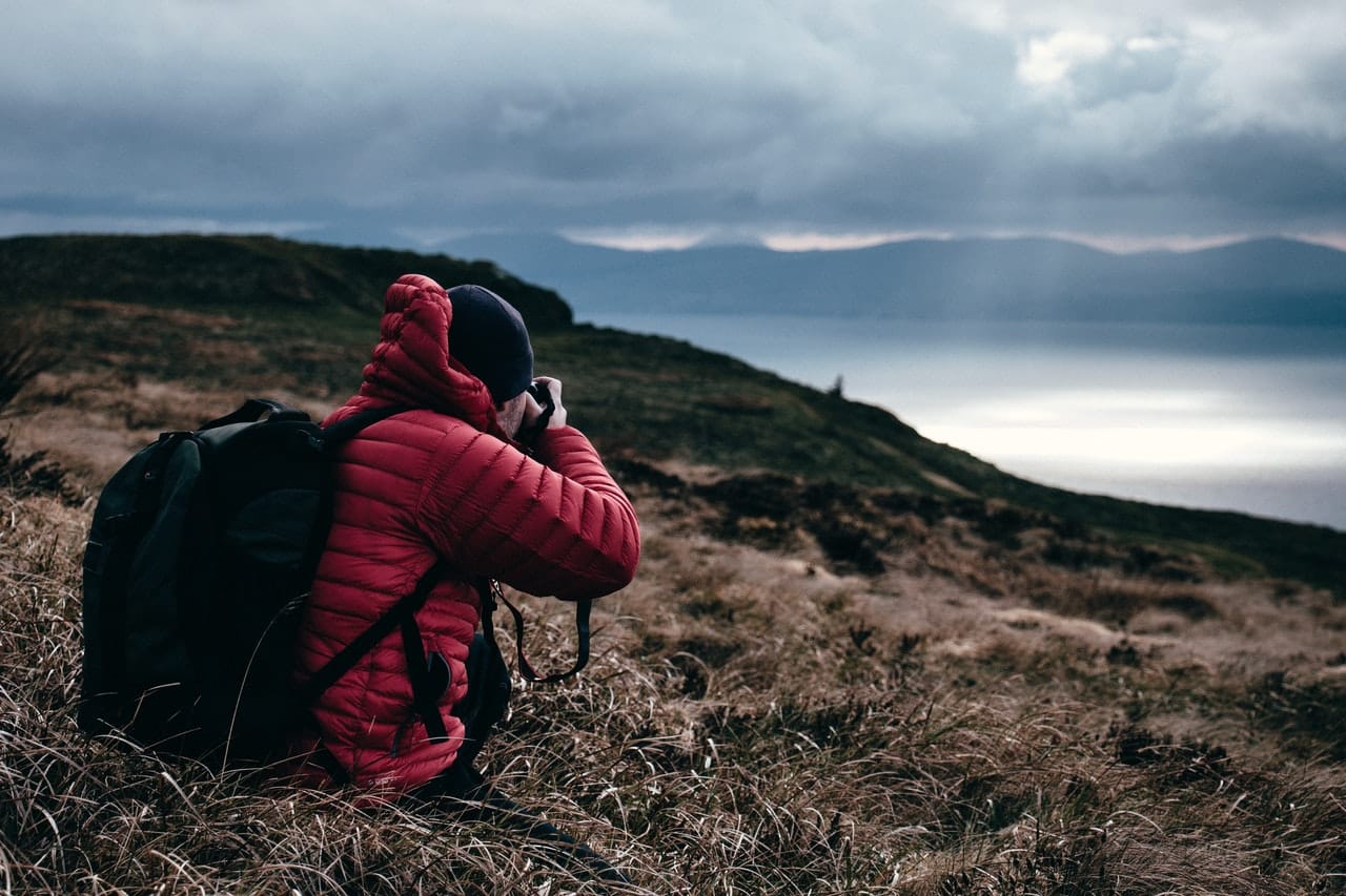 man_in_red_jacket_taking_photo