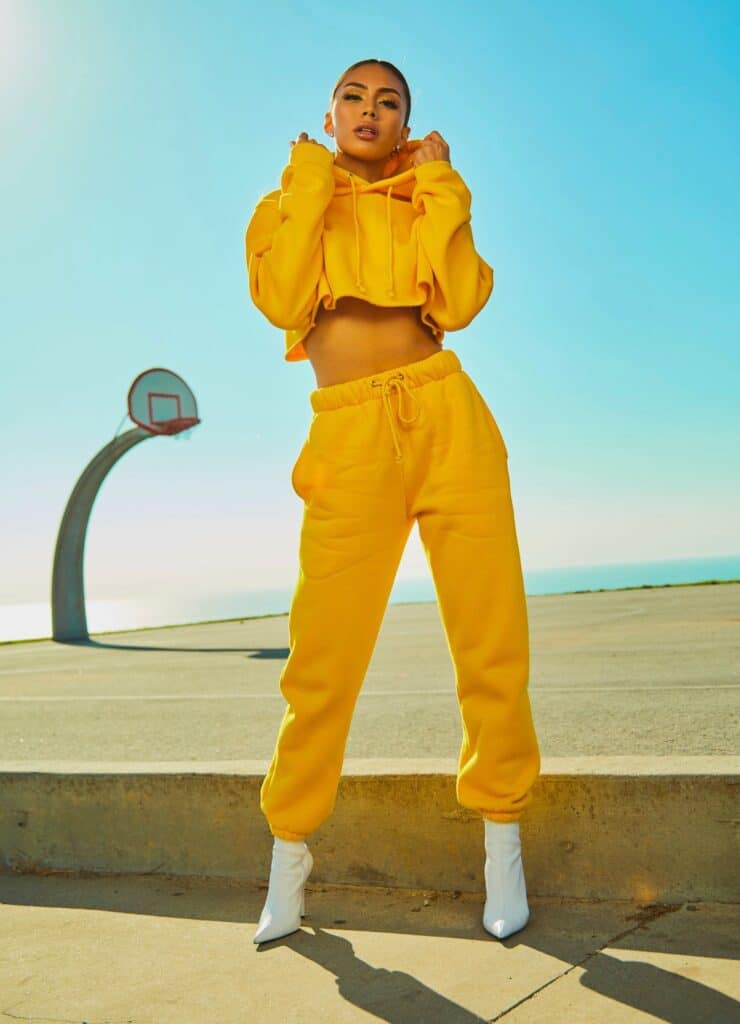 model posing in yellow cropped sweatsuit