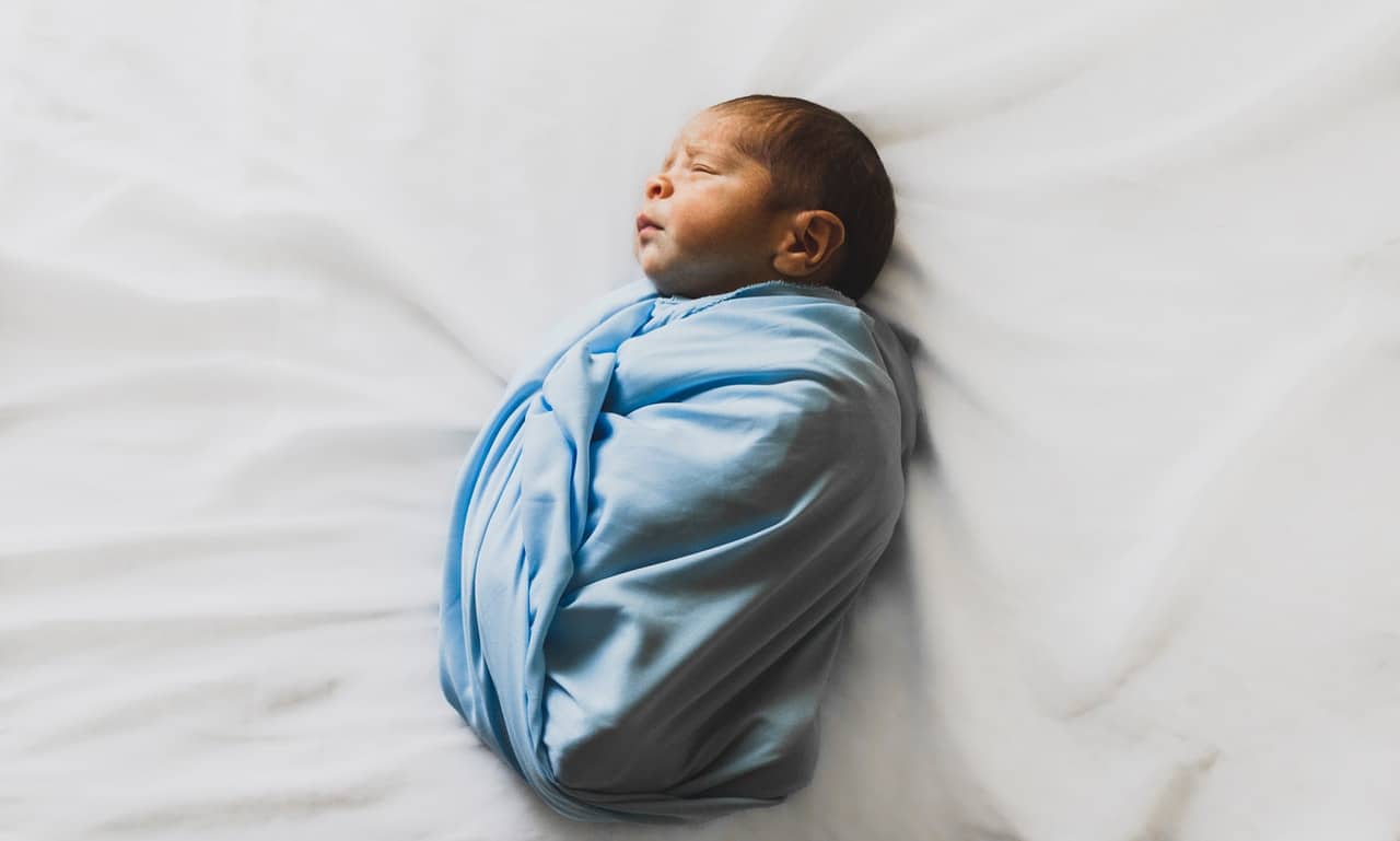 nouveau-né enveloppé dans un tissu bleu