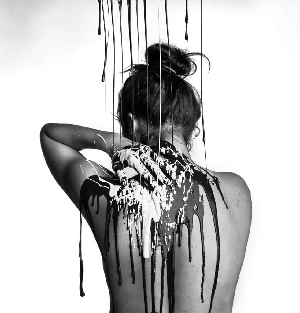 nude woman being dripped on by paint