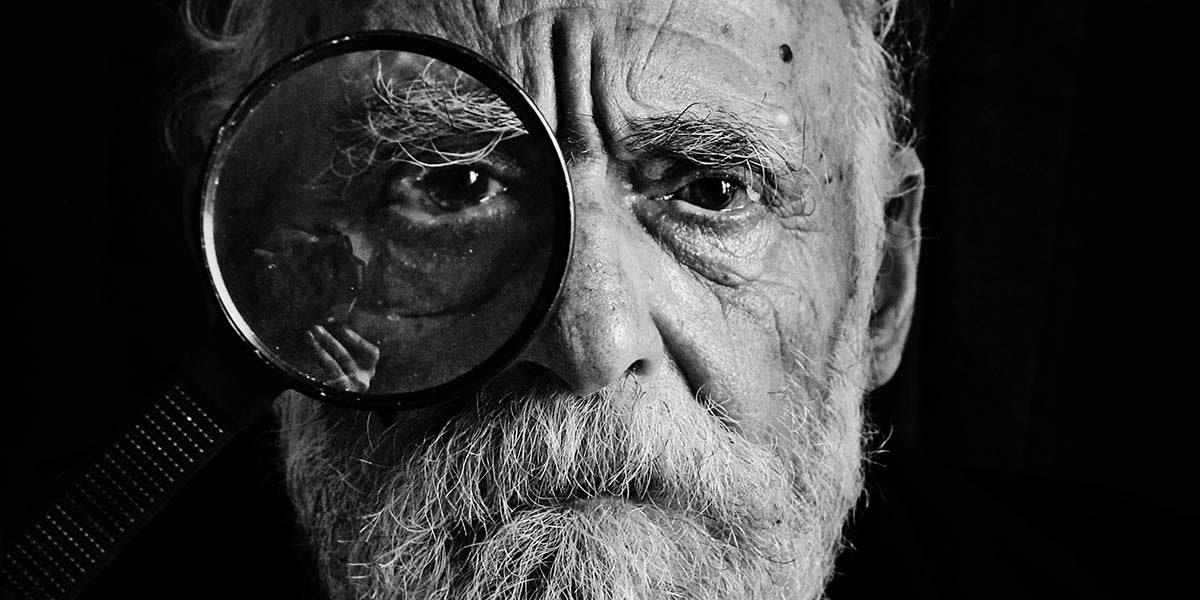 old-man-portrait-with-magnifying-glass-close-up-shot