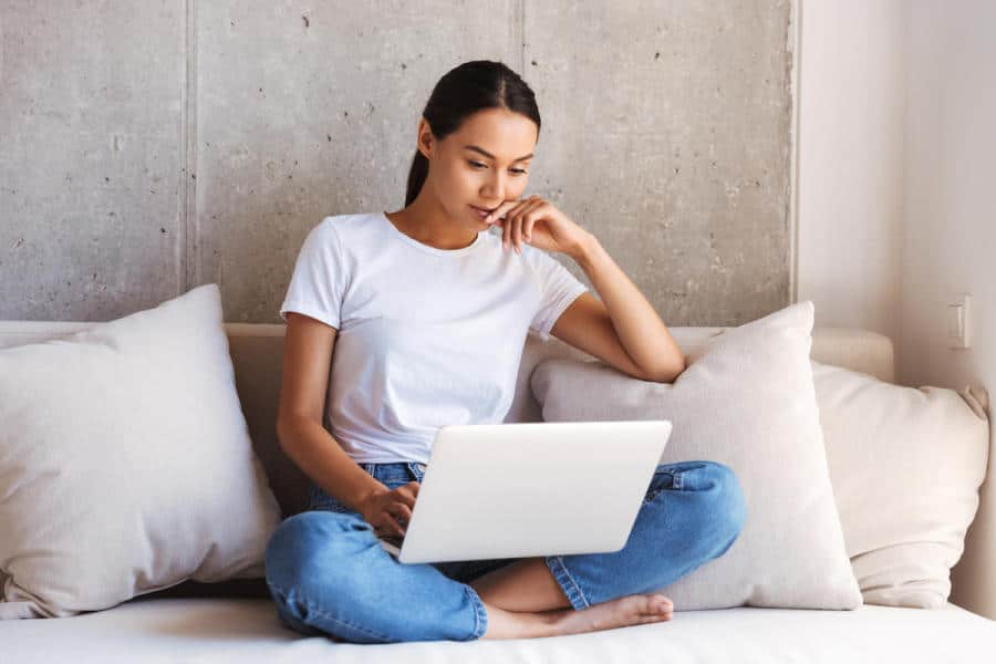 Jovem mulher asiática pensativa usando laptop YTDQWHK 1