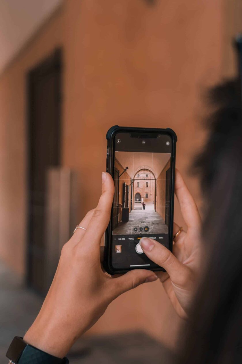 personne tenant un iphone noir en train de prendre une photo de rue à l'échelle e1687541133290