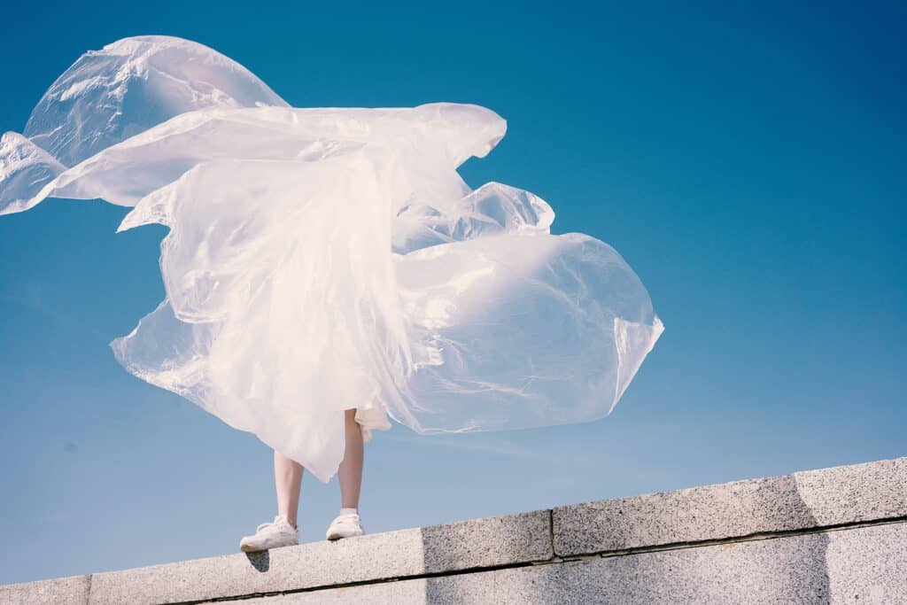 person standing on wall swathed in translucent white fabric