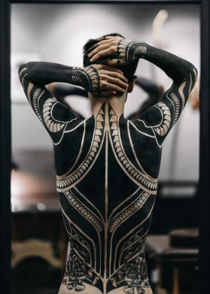 person with full back and sleeve tattoos