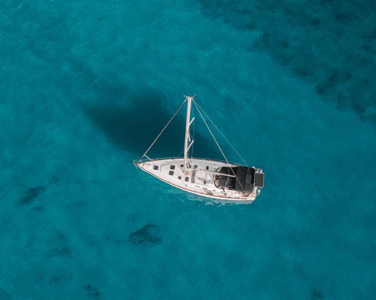 Toma aérea de un barco blanco en el agua