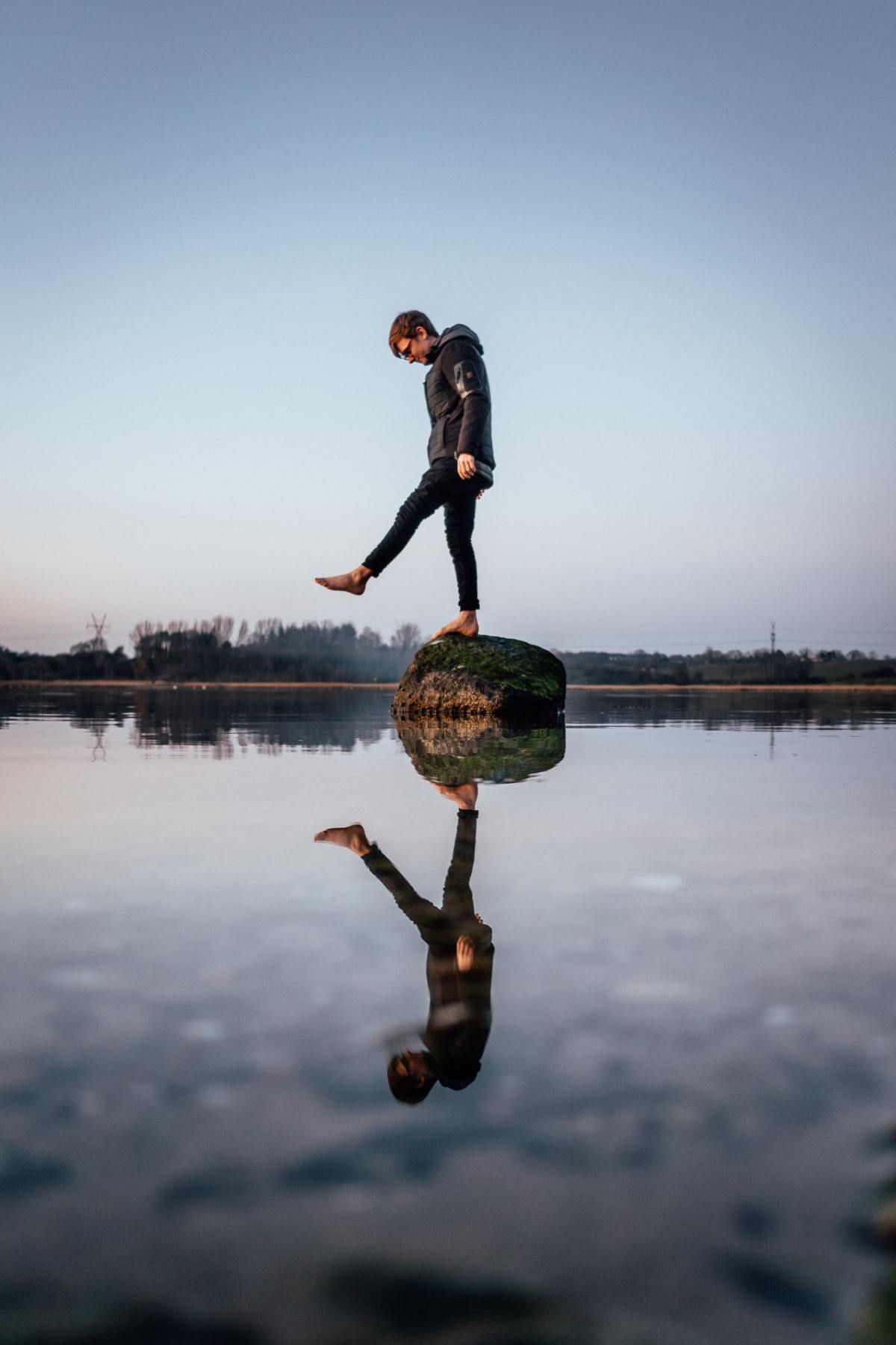 standing on rock with reflection in the water