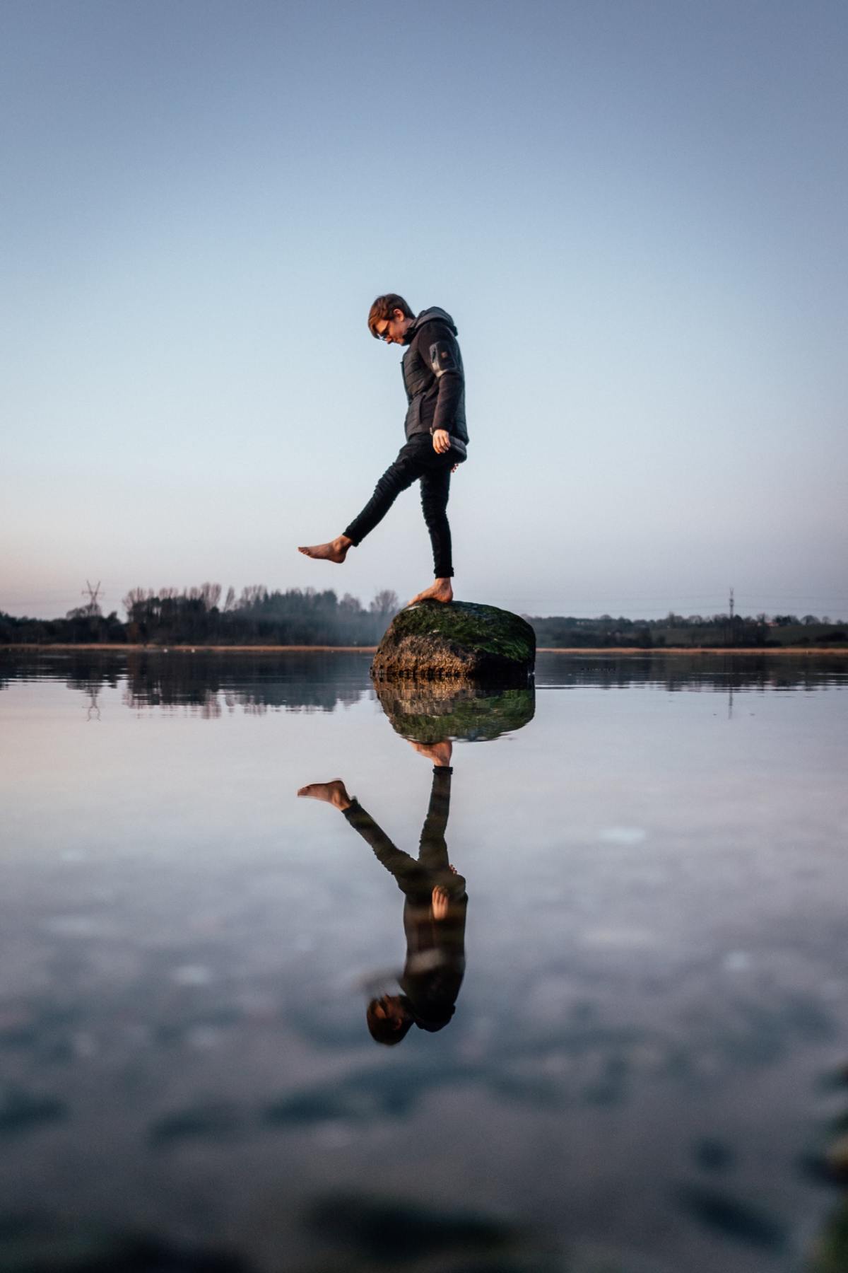 debout sur un rocher avec un reflet dans l'eau