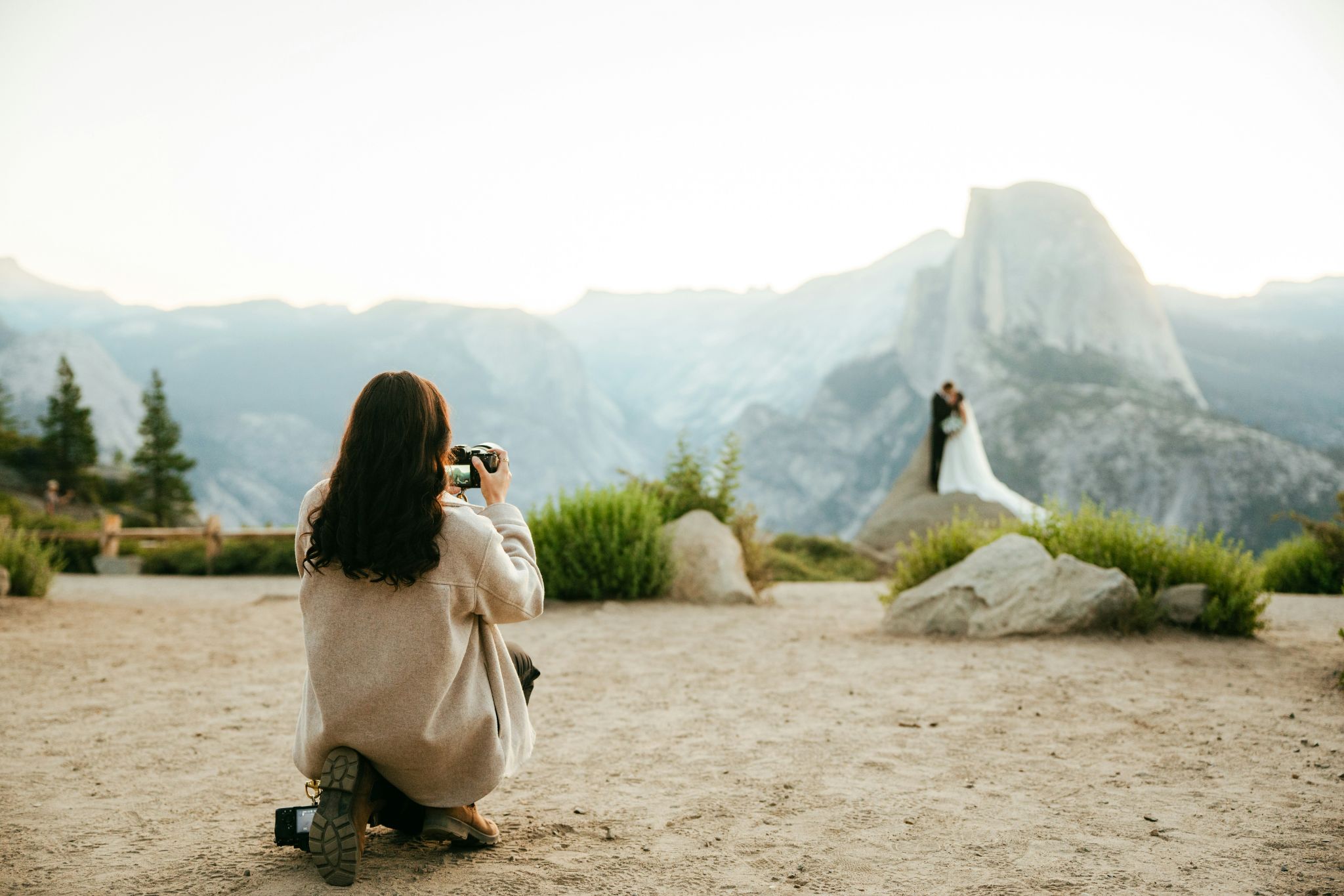 Photographer shooting a mountain wedding ceremony at sunset