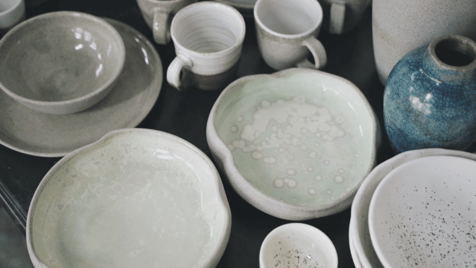 pale green and white glazed pottery plates, bowls, and mugs