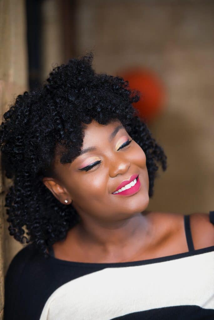 femme noire souriante avec un rouge à lèvres rouge magenta