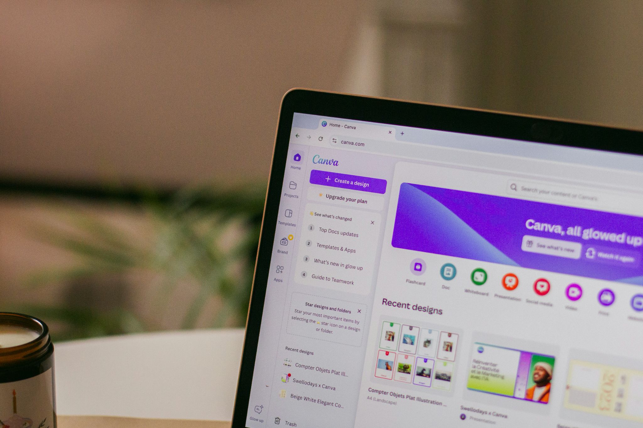 Laptop displaying Canva design dashboard with templates and recent projects