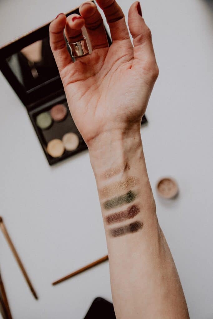 tester des échantillons de maquillage sur l'avant-bras d'une femme