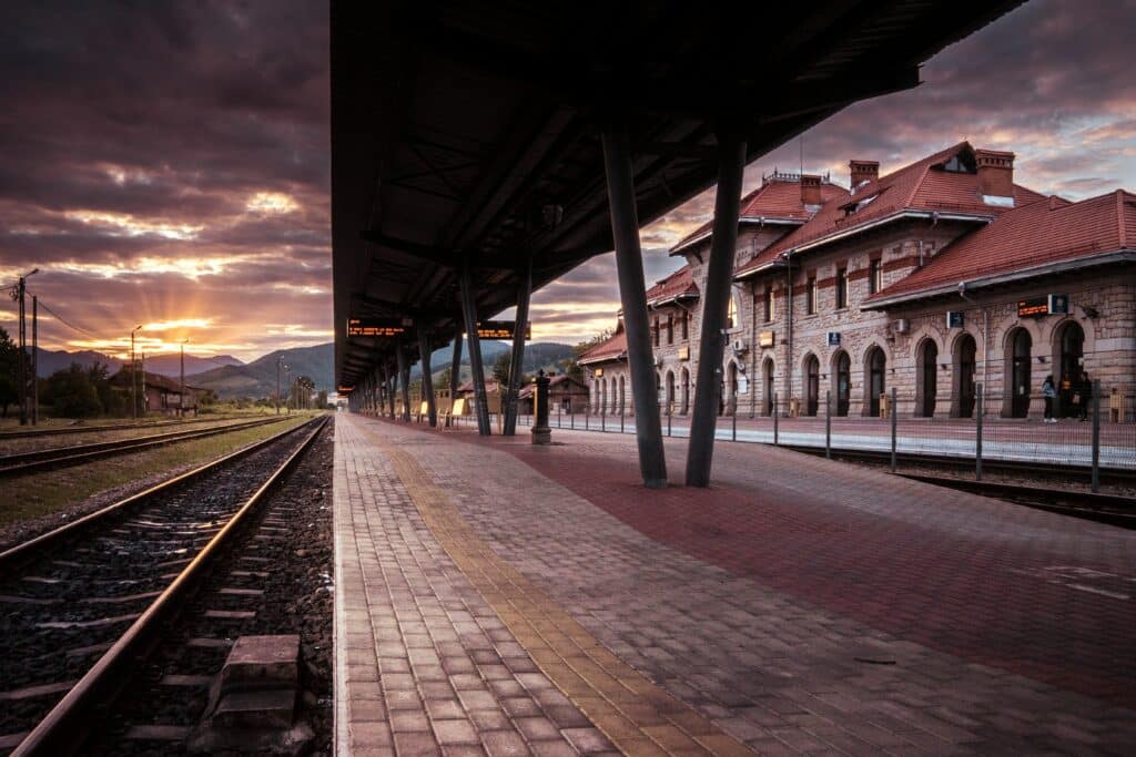 Plataforma de trem ao pôr do sol, com áreas de sombra e luz criando fortes linhas de direção