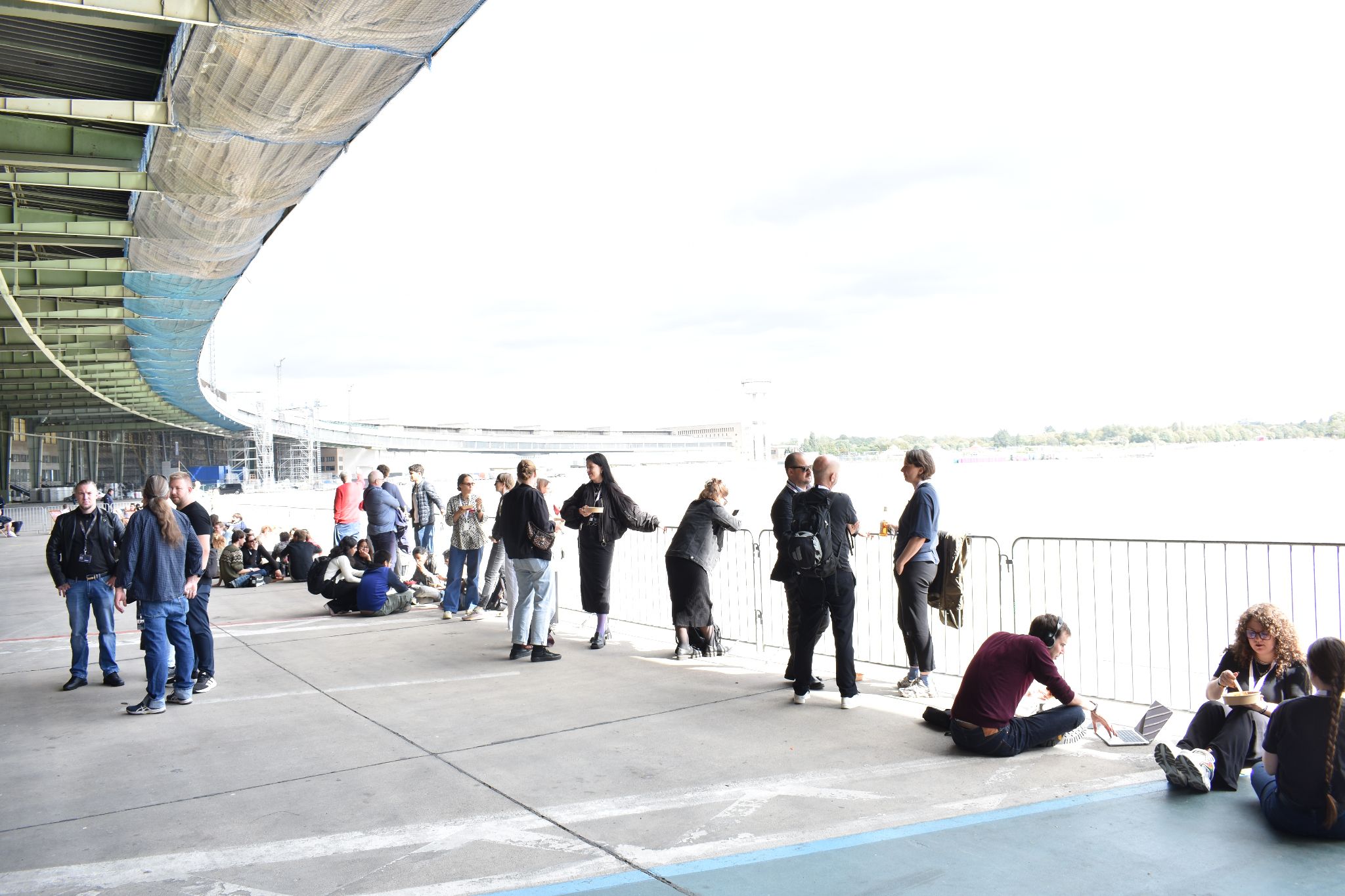 Event attendees mingle and relax beneath a modern waterfront venue canopy.