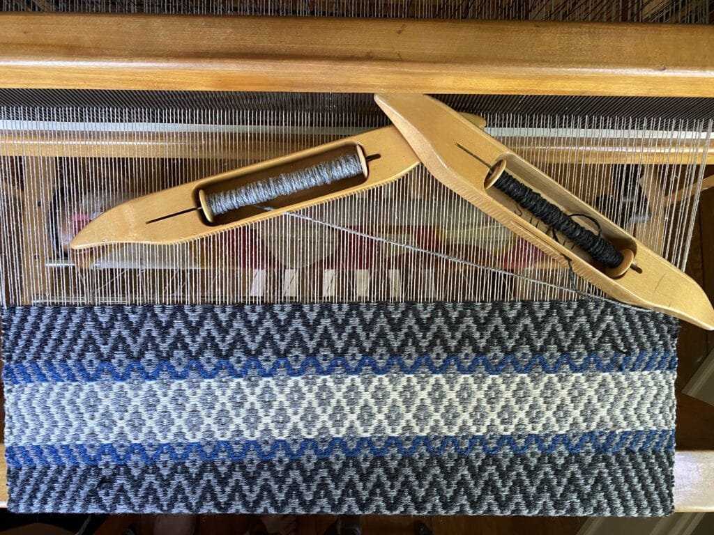 weaving tools and wool on a loom