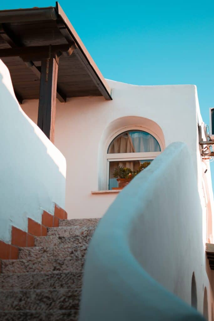 bâtiment peint en blanc en haut d'un escalier en courbe