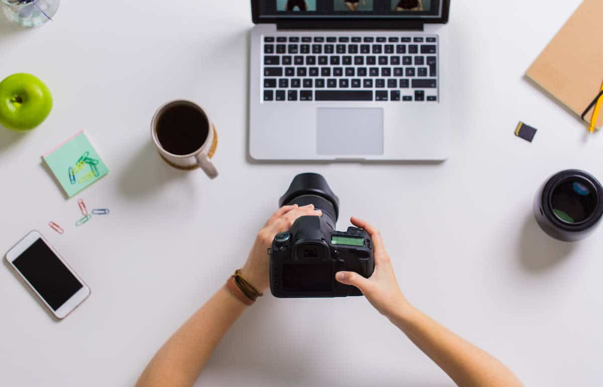 woman-hands-with-camera-working-on-laptop-at-PYSRZY9