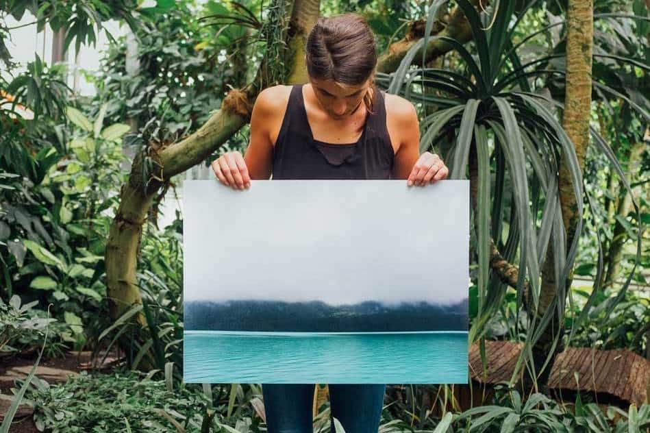 woman holding up canvas of a photograph