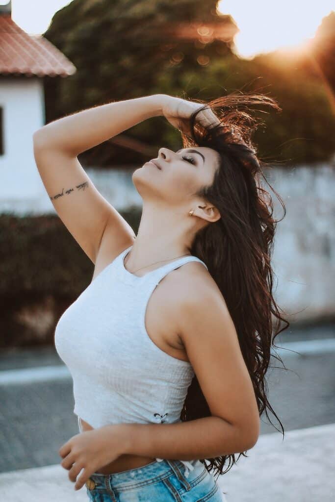 mujer posando con la espalda arqueada y la mano en el pelo