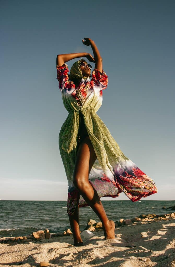 mujer posando con los brazos por encima de la cabeza en la playa