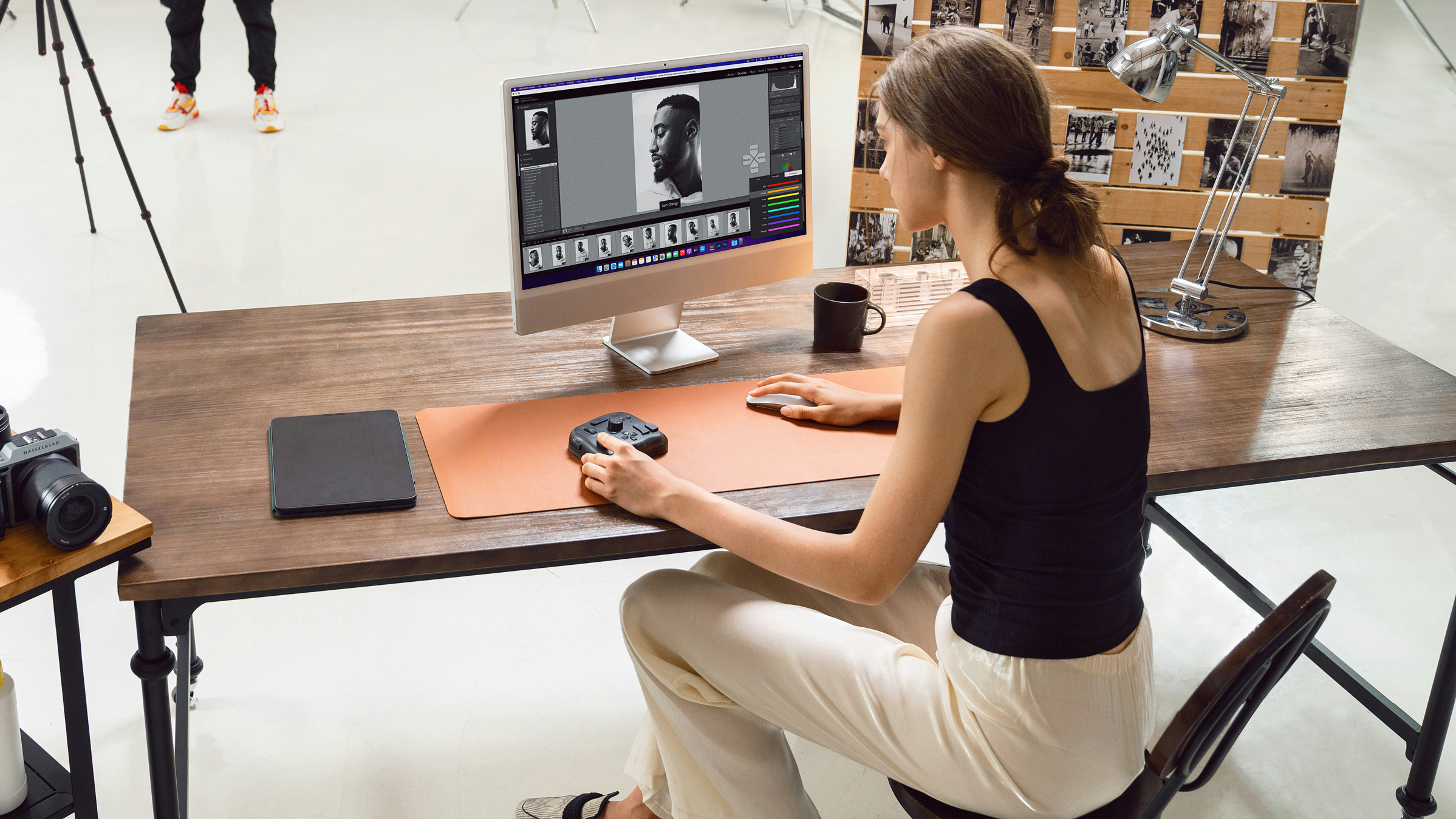 woman sitting at desk with computer using editing software in a photography studio